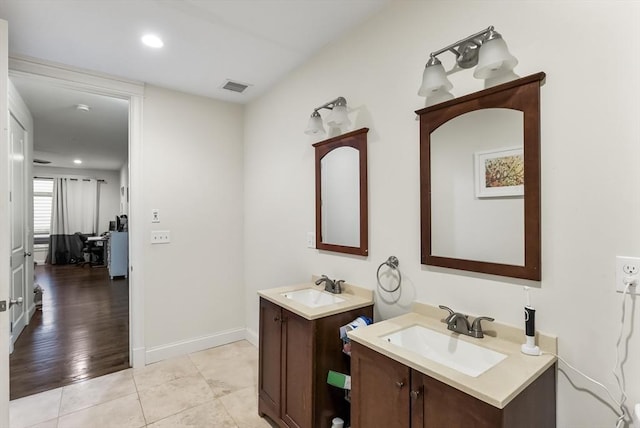 bathroom with two vanities, tile patterned floors, recessed lighting, and baseboards