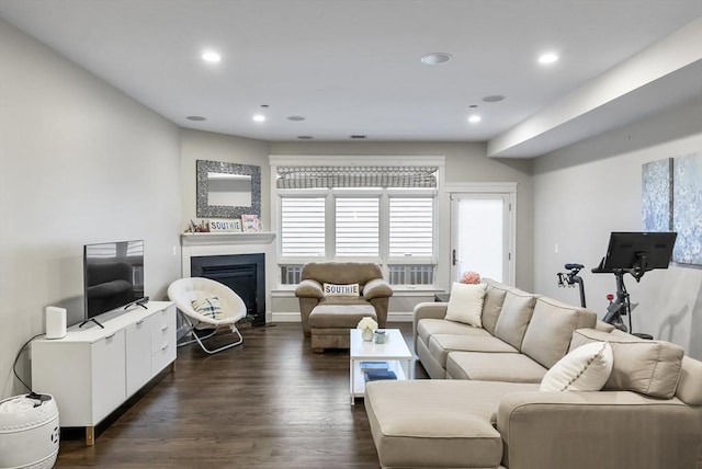 living room with dark wood finished floors, a fireplace, and recessed lighting