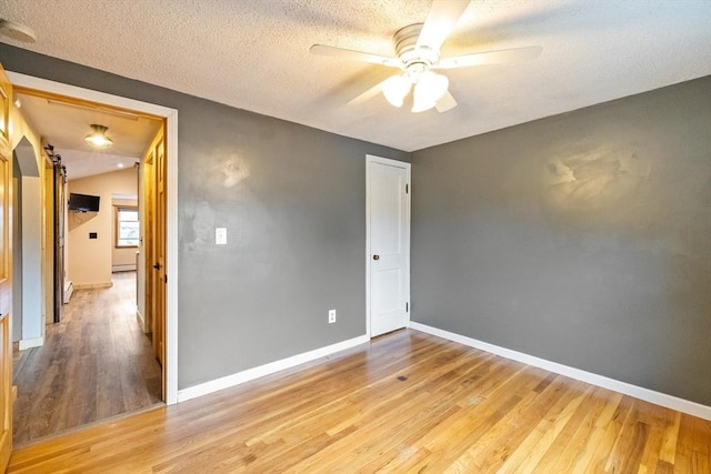 41 Yvette St, Chicopee, MA 01020 - spare room with light wood finished floors, a ceiling fan, a textured ceiling, a smoke detector, and a baseboard radiator