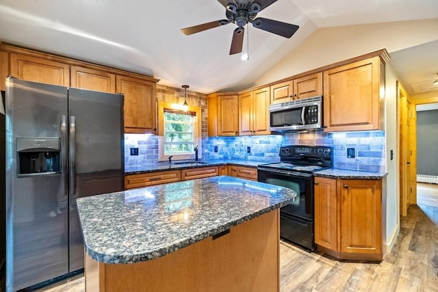 41 Yvette St, Chicopee, MA 01020 - kitchen featuring stainless steel appliances, vaulted ceiling, light wood-style floors, brown cabinetry, and dark stone countertops