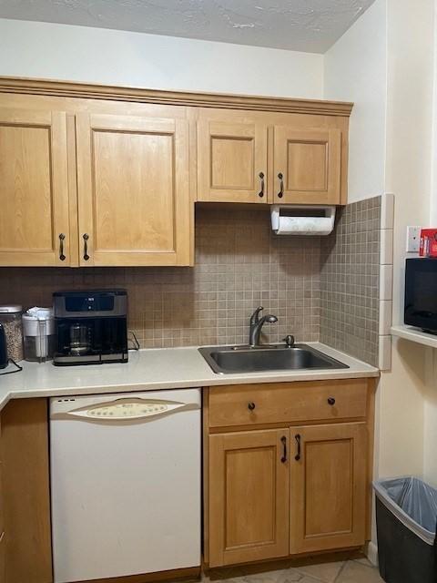 58 S St Unit 306, Quincy, MA 02169 - kitchen featuring white dishwasher, a sink, decorative backsplash, and light countertops