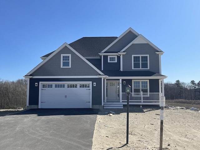 view of front of property featuring covered porch and a garage