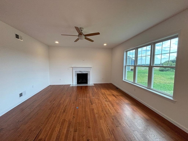 unfurnished living room featuring ceiling fan, dark hardwood / wood-style flooring, and a fireplace