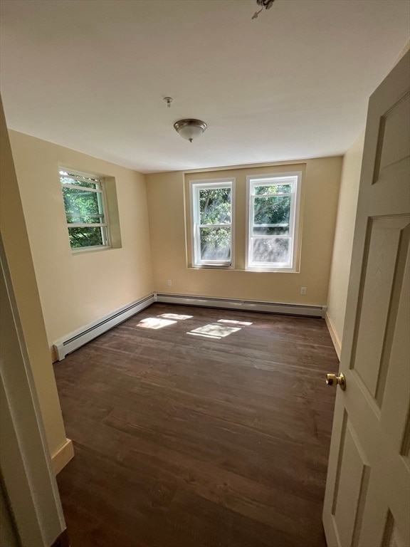 spare room featuring dark hardwood / wood-style floors and baseboard heating