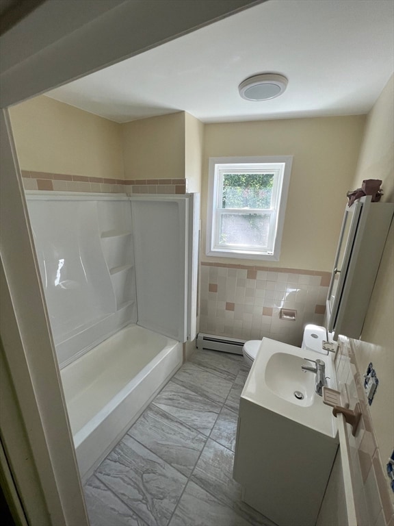 bathroom featuring a baseboard radiator, walk in shower, toilet, vanity, and tile walls