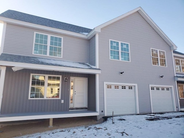 view of front of home with a garage and a shingled roof