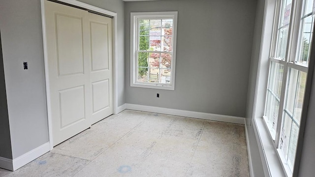 unfurnished bedroom with a closet and baseboards