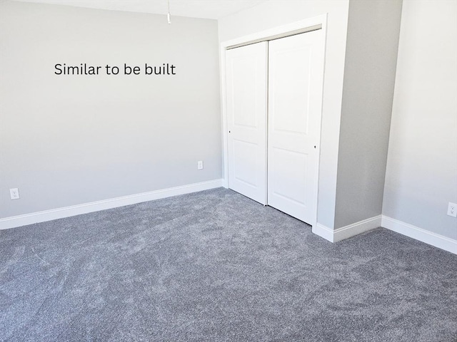 unfurnished bedroom featuring baseboards, dark colored carpet, and a closet