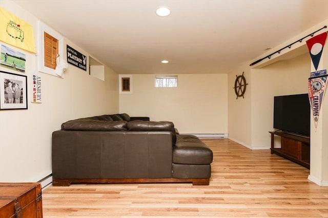 living room featuring a baseboard heating unit and light hardwood / wood-style flooring