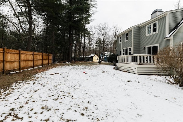 yard covered in snow with a deck