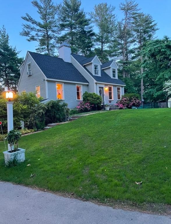 new england style home featuring a front yard