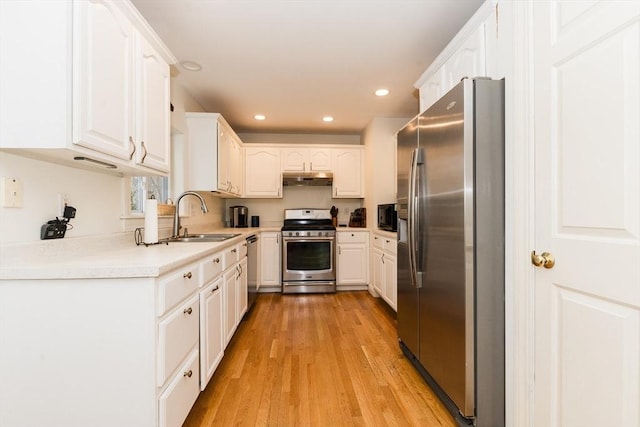 kitchen featuring sink, appliances with stainless steel finishes, light hardwood / wood-style flooring, and white cabinetry