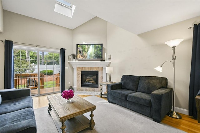 7 Myra Ln Unit 11, Worcester, MA 01606 - living room featuring wood finished floors, a skylight, a tile fireplace, lofted ceiling, and baseboards