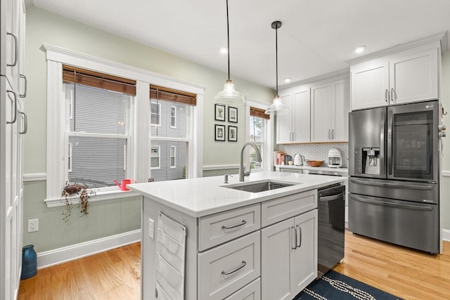 kitchen featuring stainless steel fridge with ice dispenser, a sink, light countertops, light wood-style flooring, and recessed lighting