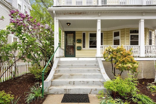 property entrance with a porch and fence
