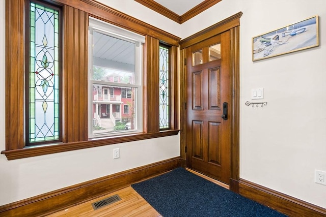 foyer entrance with baseboards, ornamental molding, and wood finished floors