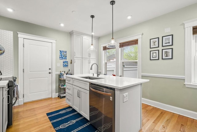 kitchen featuring appliances with stainless steel finishes, a sink, light wood-style flooring, light countertops, and recessed lighting