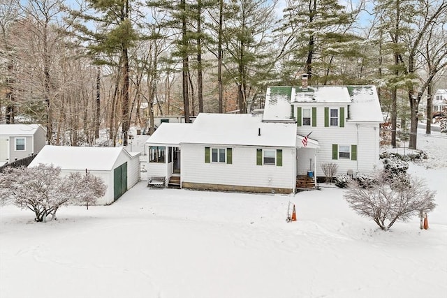 view of snow covered back of property