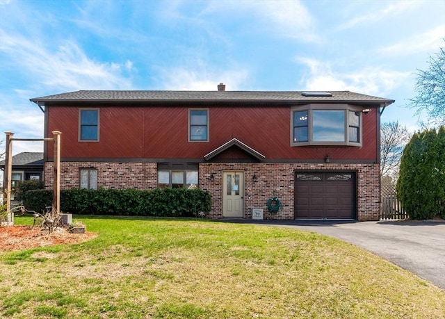 view of front of property featuring brick siding, aphalt driveway, a front yard, and an attached garage