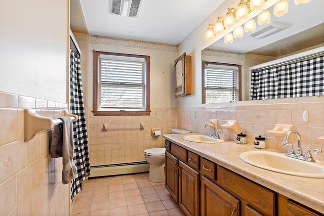 full bath featuring tile patterned floors, a baseboard radiator, tile walls, and a sink