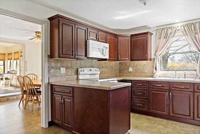 kitchen with light countertops, a sink, backsplash, and white appliances