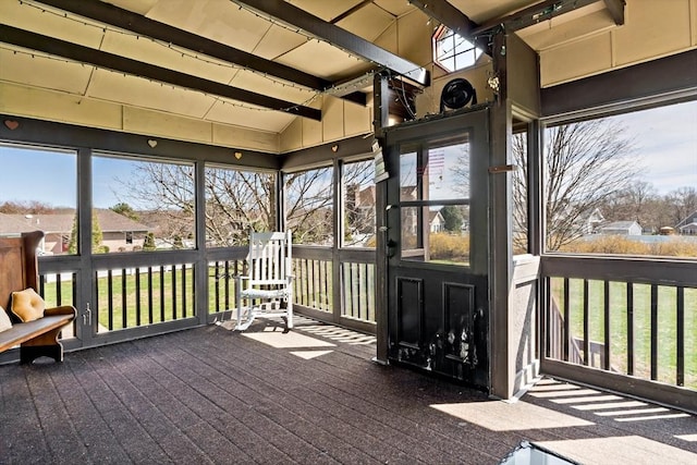 sunroom with a residential view, beam ceiling, and a wealth of natural light