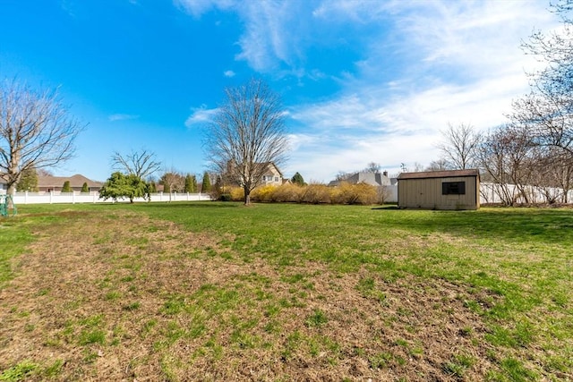 view of yard featuring fence, an outdoor structure, and a storage shed