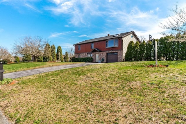 view of front of house with brick siding, a front lawn, an attached garage, and aphalt driveway