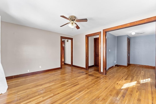 spare room featuring light wood-style floors, baseboards, and a ceiling fan