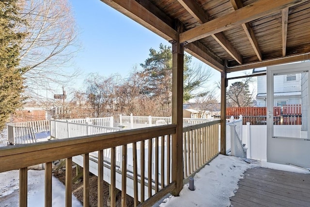 snow covered deck featuring a fenced backyard