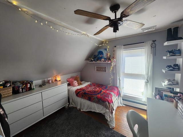 bedroom featuring a baseboard heating unit, lofted ceiling, ceiling fan, and wood finished floors