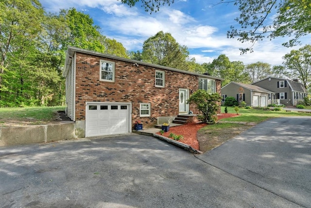 split foyer home featuring driveway, an attached garage, and brick siding
