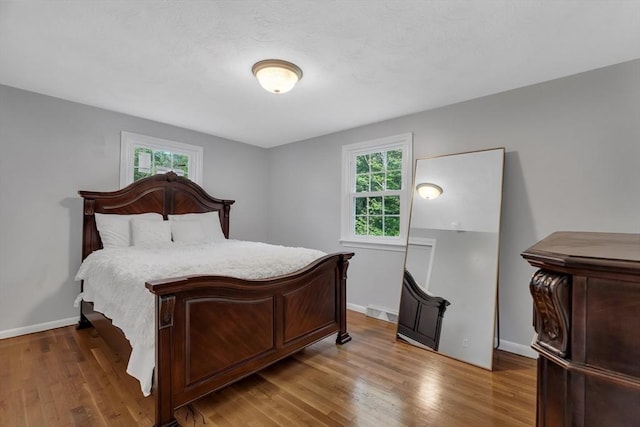 bedroom featuring wood finished floors and baseboards