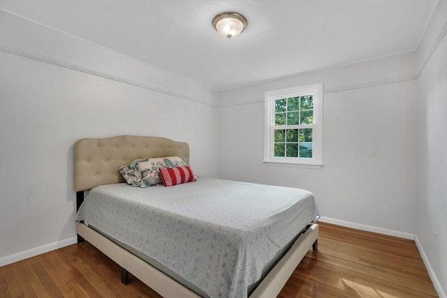 bedroom featuring baseboards and wood finished floors