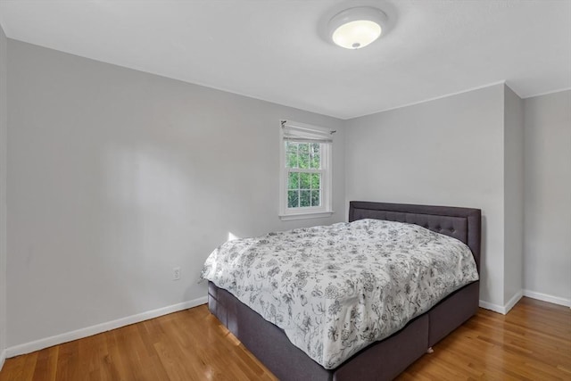 bedroom with wood finished floors and baseboards