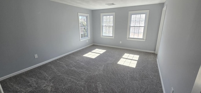 spare room with carpet floors, visible vents, and baseboards