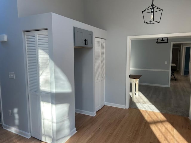 corridor featuring baseboards and wood finished floors