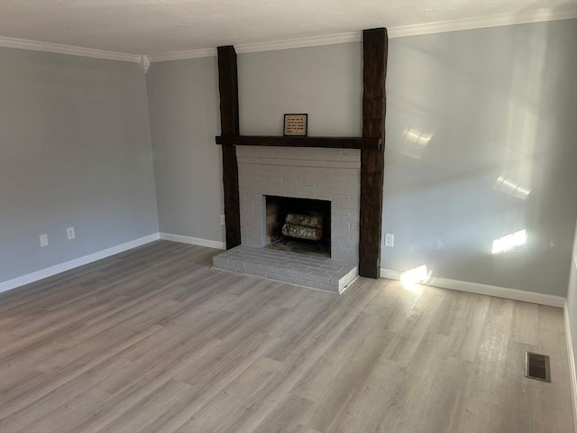 unfurnished living room featuring baseboards, visible vents, crown molding, and wood finished floors