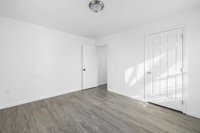 unfurnished bedroom with baseboards and wood finished floors