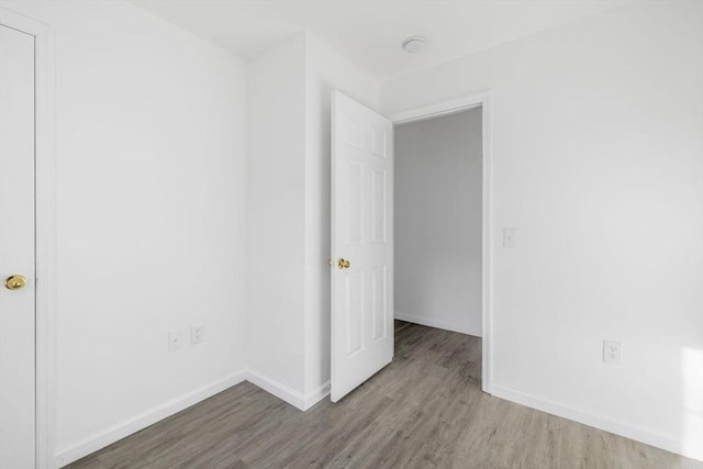 unfurnished bedroom featuring baseboards and wood finished floors