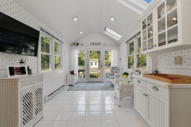 unfurnished sunroom featuring a baseboard radiator and lofted ceiling with skylight