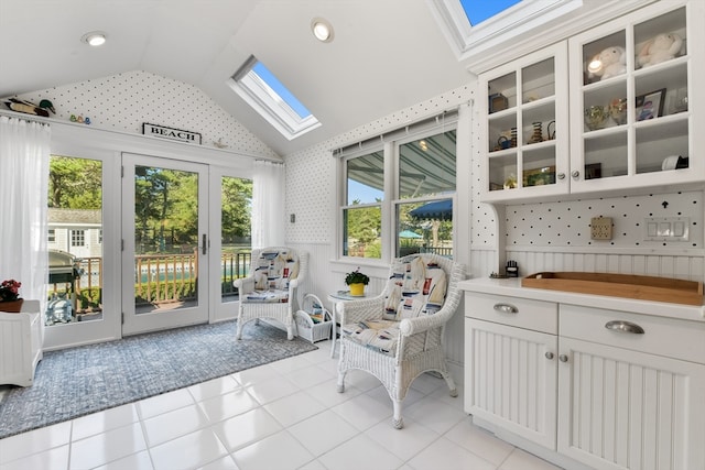 sunroom / solarium featuring lofted ceiling with skylight