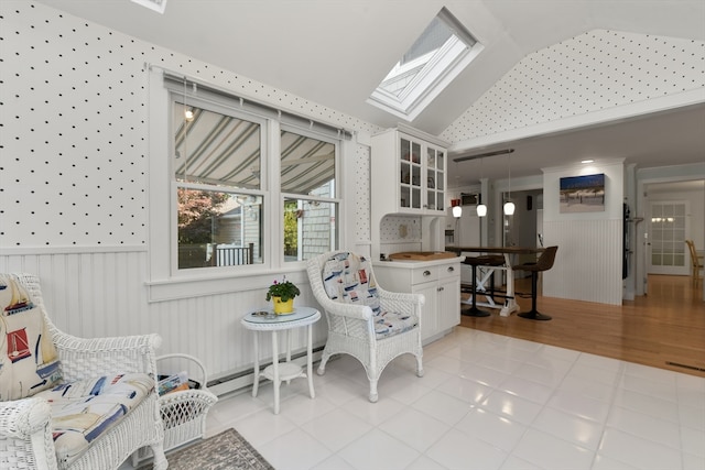 interior space with light tile patterned floors and lofted ceiling with skylight