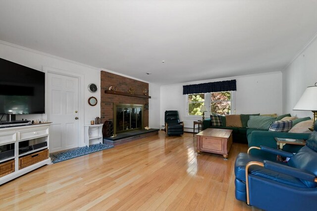 living room with a baseboard heating unit, a brick fireplace, light hardwood / wood-style floors, and ornamental molding