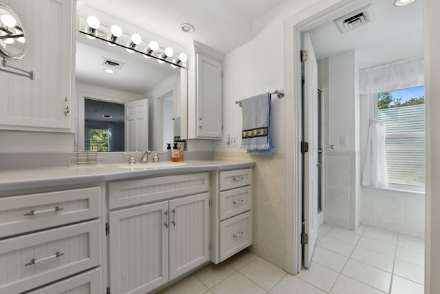 bathroom with tile patterned flooring, tile walls, and vanity