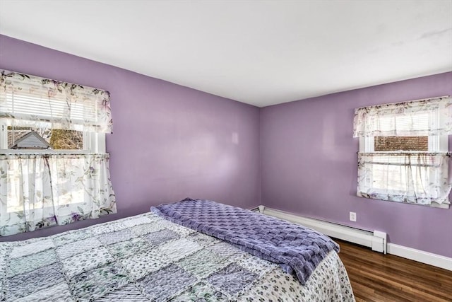 bedroom with baseboard heating and dark hardwood / wood-style flooring