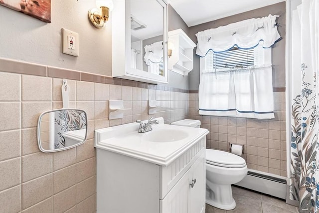 bathroom featuring tile patterned flooring, tile walls, toilet, vanity, and baseboard heating