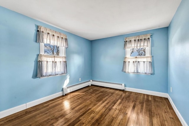 spare room with a baseboard radiator and hardwood / wood-style floors