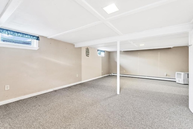 basement with a baseboard heating unit and carpet