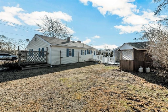 rear view of house with a yard and a wooden deck